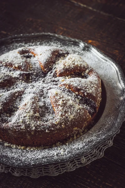 Cake with icing sugar on the vintage metal plate vertical — Stock Photo, Image