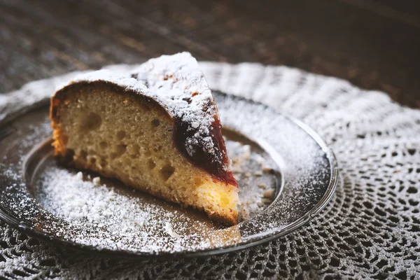 Pezzo di torta con zucchero a velo e marmellata sul tovagliolo di pizzo — Foto Stock