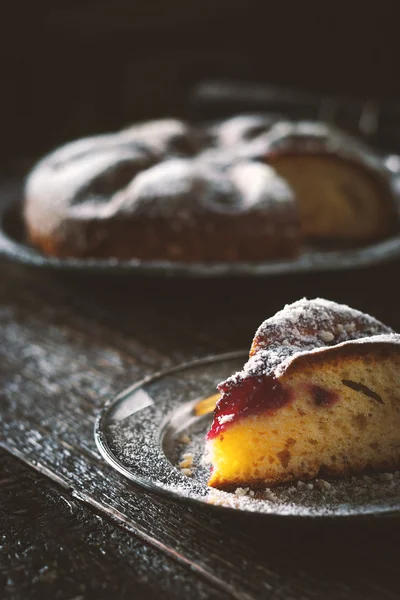 Cake with powdered sugar with a piece cut off vertical — Stock Photo, Image