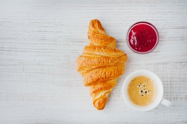 Croissant with cup of coffee and jam top view clipart
