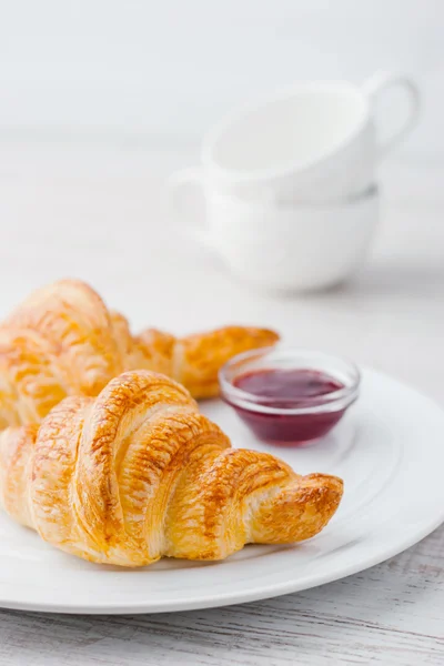 Croissant con marmellata ant due tazze in ceramica bianca verticali — Foto Stock