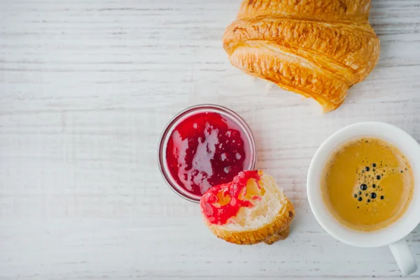 Croissant immerso nella marmellata di frutti di bosco con una tazza di caffè vista dall'alto — Foto Stock
