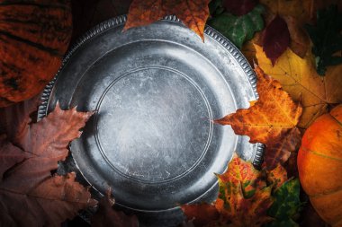 Eski metal plaka sonbahar yaprakları ve kabak ile yuvarlak