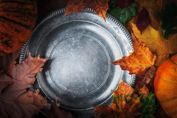 Стара кругла металева тарілка з осіннім листям та гарбузами — стокове фото