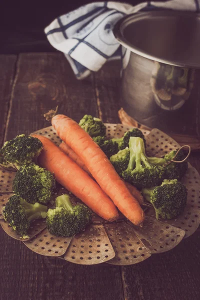 Steamed carrots and broccoli on the wooden table — Stock Photo, Image