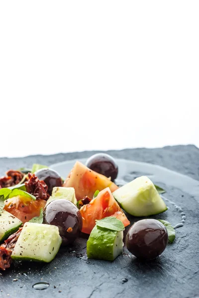 Vegetabilsk salat på det sorte steinbordet – stockfoto