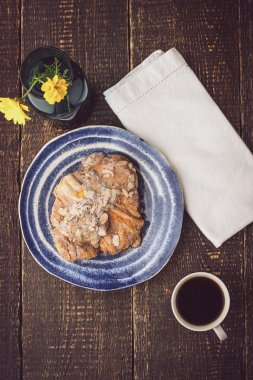 Cup of coffee with croissant and flower top view