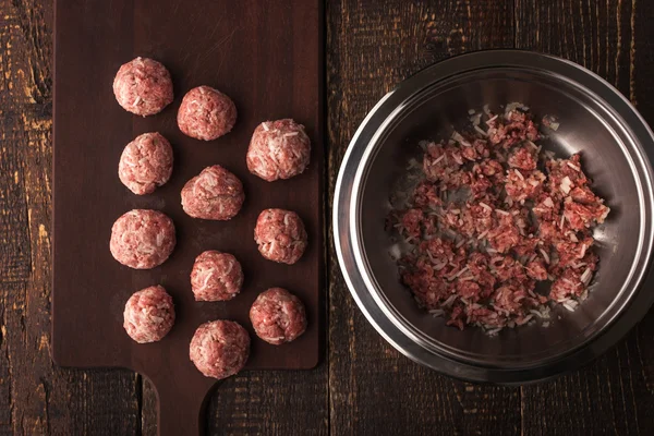 Meatballs on the wooden board with stuffing in a pan top view horizontal — Stock Photo, Image