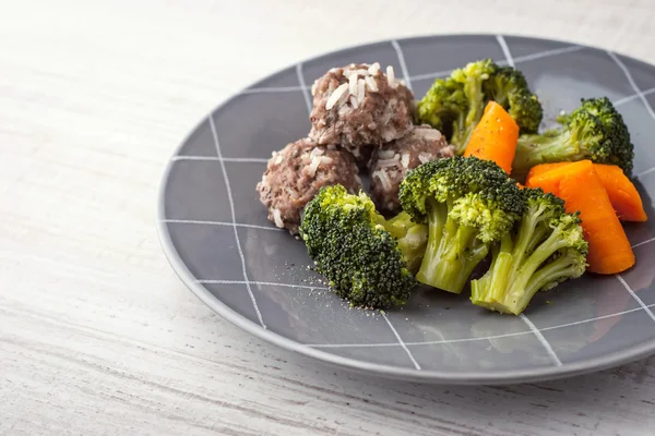 Carrots and broccoli with meatballs on the grey plate horizontal — Stock fotografie