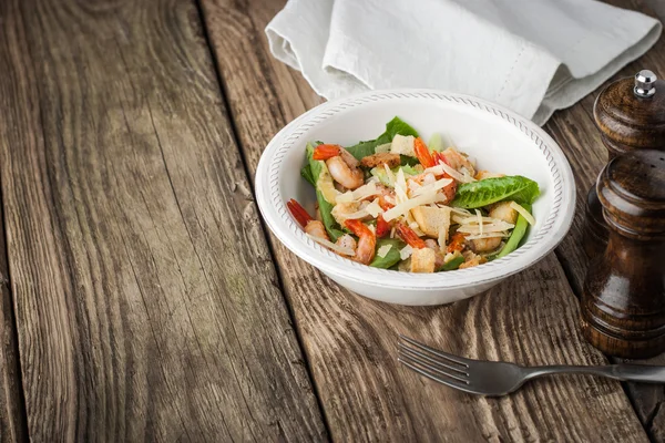 Salada com camarões, croutons e verduras na mesa de madeira horizontal — Fotografia de Stock