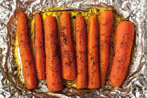 Cenouras assadas com pimenta preta em uma folha de folha de folha vista superior — Fotografia de Stock