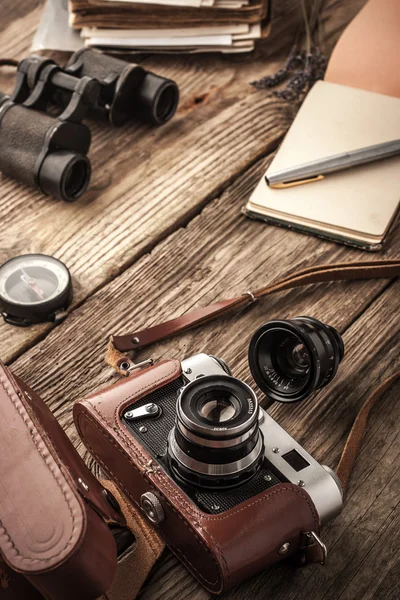 Kamera mit Notizbuch und Fernglas auf dem Holztisch — Stockfoto