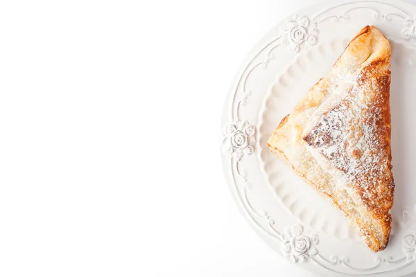 Cream puff with powdered sugar on the white plate top view — Stock Photo, Image