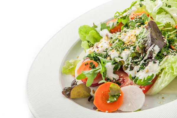 Овочевий салат з зеленню та кунжутом на білій тарілці — стокове фото