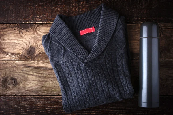 Сірий светр і термос на дерев'яному фоні — стокове фото