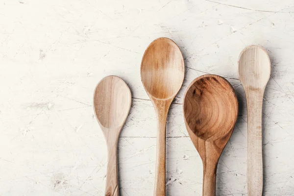 Cucchiai di legno sul tavolo bianco orizzontale — Foto Stock