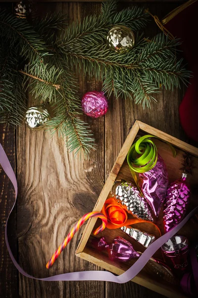 Wooden box with Christmas tree decorations and candy top view — Stock Photo, Image