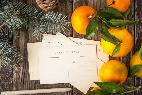 Postcards with fir tree and mandarins on the wooden table — Stock Photo, Image