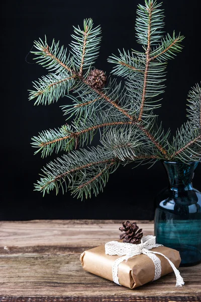 Fir tree branch in the vase with present — Stock Photo, Image