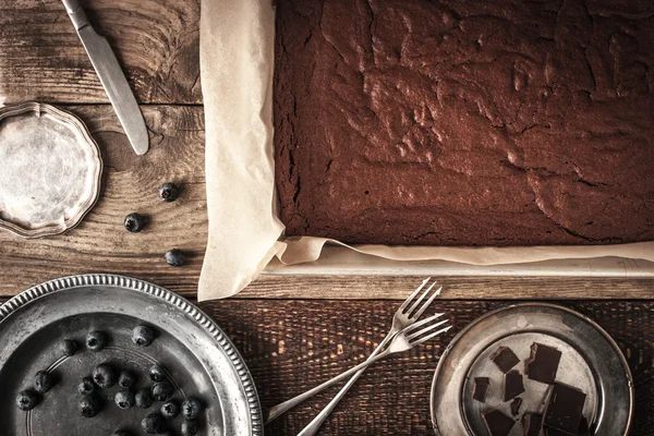 Bolinho de chocolate na assadeira com mirtilo e pratos horizontais — Fotografia de Stock