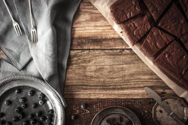 Slices of chocolate brownie with blueberry and vintage dinnerware horizontal