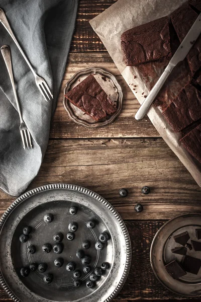 Кусочки шоколадного кекса с черникой и винтажными блюдами по вертикали — стоковое фото