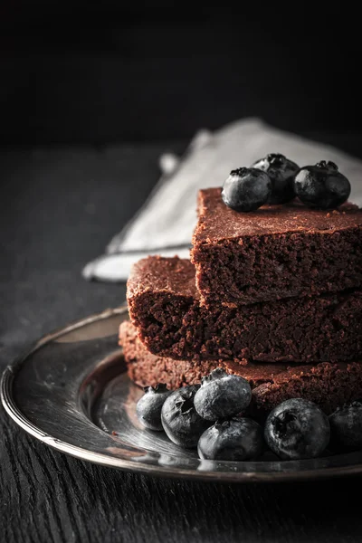 Choklad brownie med blåbär på tabellen svart vertikala — Stockfoto