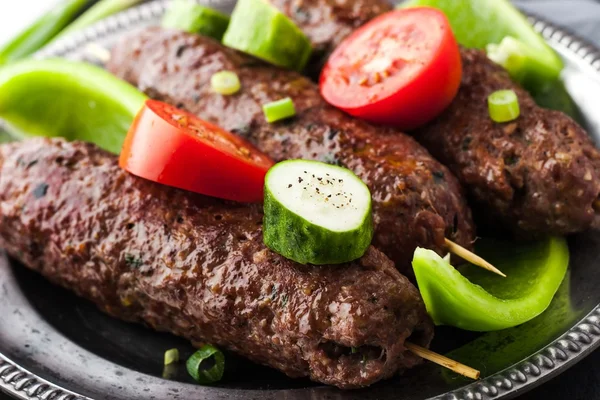 Kebabs con verduras en la placa de metal vintage de cerca — Foto de Stock