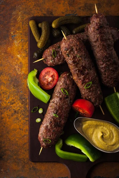 Kebabs with vegetables on the colorful stone table top view — Stock Photo, Image