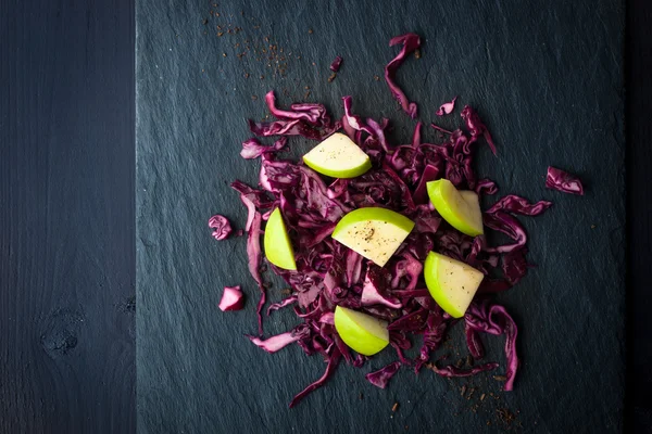 Kål og epler salat på den mørke steintoppen – stockfoto