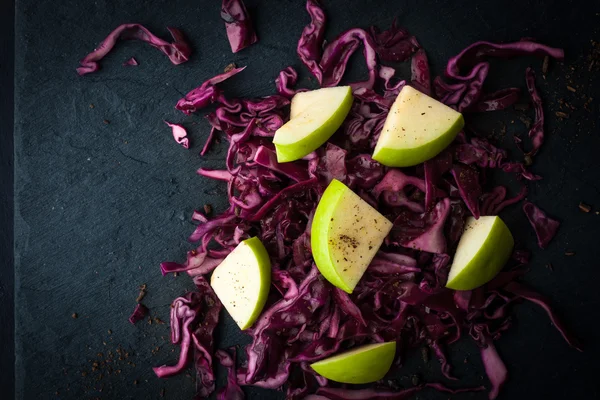 Sallad på rödkål och äpplen på den mörka sten ovanifrån — Stockfoto