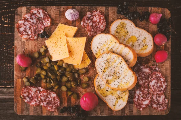 Different snack on the wooden board top view — Stock Photo, Image