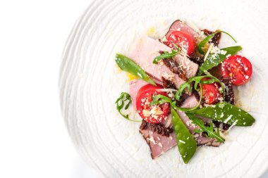 Beyaz tabak üstten görünüm üzerinde füme jambon ve Roka Salatası