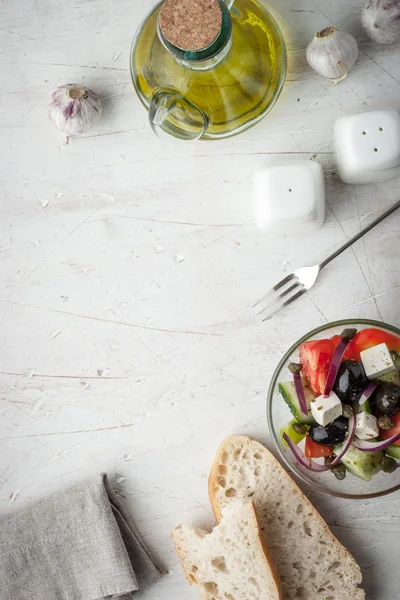 Ensalada griega con aceite de oliva, tenedor y pan —  Fotos de Stock