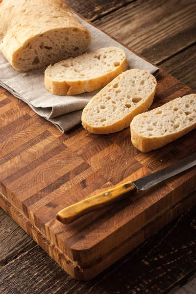 Нарезанный хлеб на деревянной доске вертикально — стоковое фото