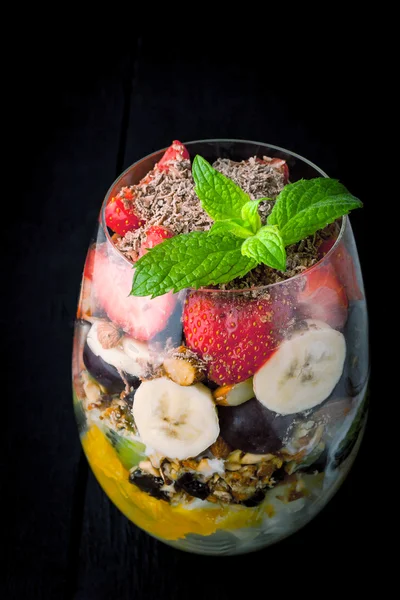 Ensalada de frutas en el vaso sobre la mesa oscura —  Fotos de Stock