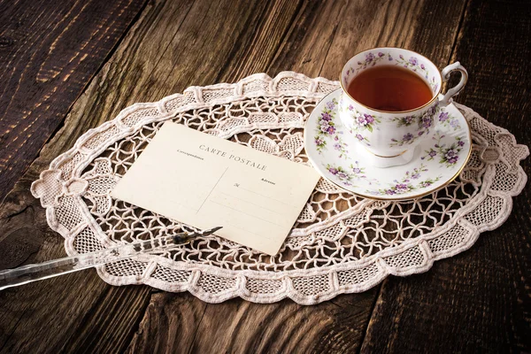 Taza de té con postal y pluma horizontal —  Fotos de Stock