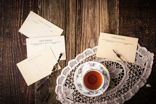 Postales con taza de té en la mesa de madera horizontal —  Fotos de Stock