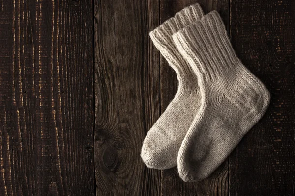 Chaussettes en laine tricotées sur la planche en bois vue du dessus — Photo