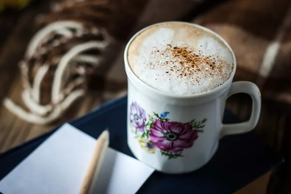 Taza de capuchino con papel borroso y lápiz horizontal —  Fotos de Stock