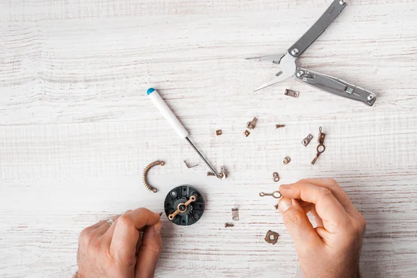 Workers assemble a mechanism with a screwdriver and pliers — Stock Photo, Image