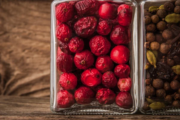 Getrocknete Preiselbeeren und Gewürze auf einem Holztisch — Stockfoto