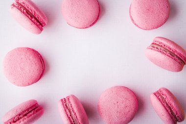 Beyaz masa örtüsü üzerinde pembe acıbadem kurabiyesi