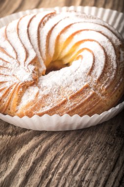 Ahşap bir masa üzerine pudra şekeri pastada