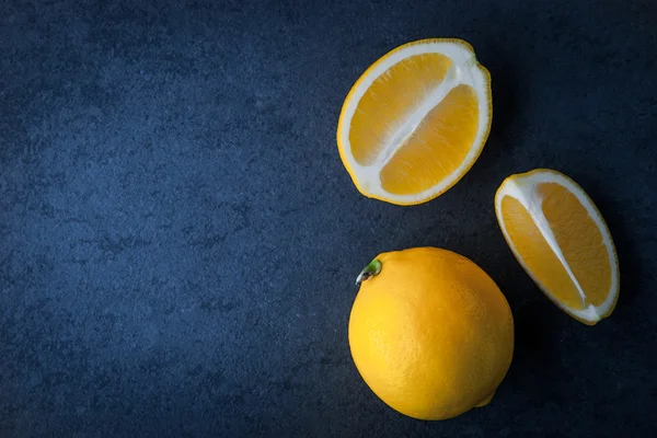 Желтые лимоны на синем каменном столе — стоковое фото
