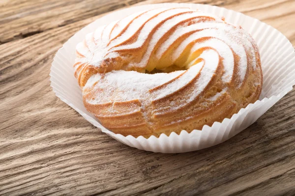 Kakku jauhettua sokeria puinen pöytä — kuvapankkivalokuva