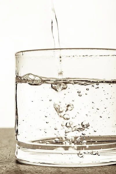 Glas med vatten på den vita bakgrunden — Stockfoto
