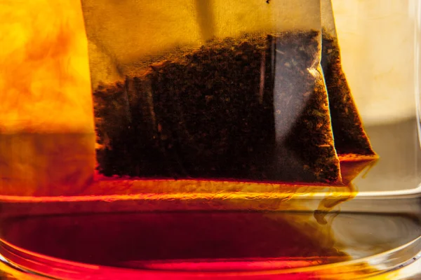 Bolsa de té en la taza de vidrio con agua de cerca - hasta —  Fotos de Stock