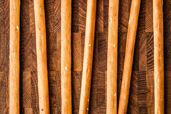 Bâtonnets de pain salé reposent sur une planche à découper — Photo