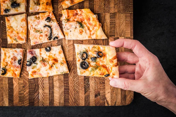 Slices of pizza on a wooden board — Stock Photo, Image